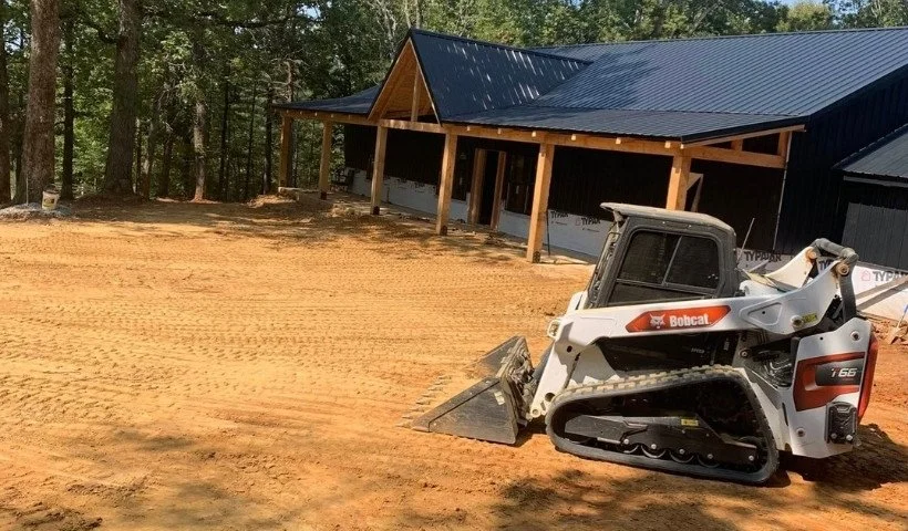 Land grading and leveling for new construction with skid steer near building pad in Middle Tennessee