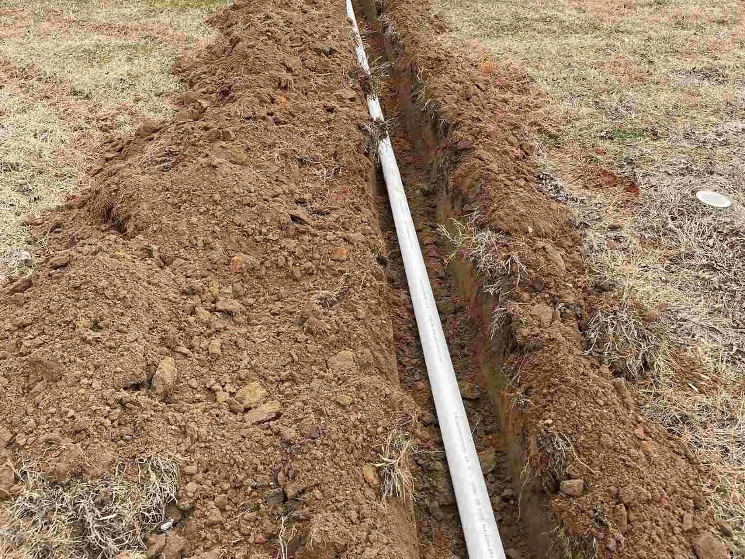 Sewer line PVC pipe laid in residential yard trench for underground sewer installation McMinnville TN