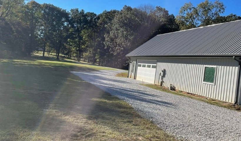 Gravel driveway installation with ¾ inch stone leading to metal shop building in Middle Tennessee