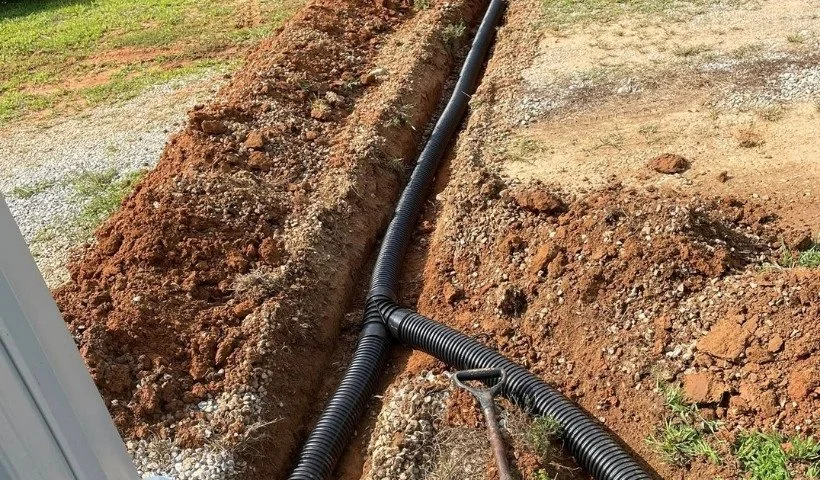 Trenching and underground drain pipe installation for residential drainage system