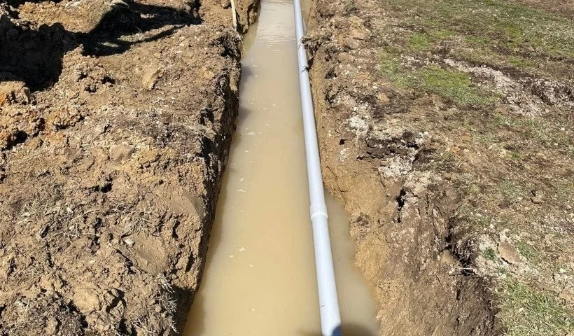 Sewer line excavation and pipe installation with proper grading to ensure smooth water flow.