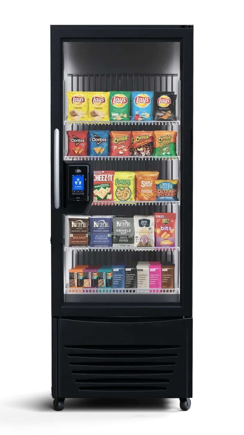 A vending machine stocked with various snacks including Lay's chips, Doritos, Cheetos, Cheez-It, Fritos, SunChips, Rold Gold pretzels, kettle potato chips, and candy bars, with a digital payment terminal on the left side.