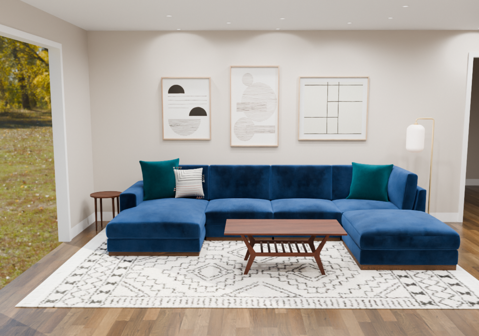 A living room with a large blue sectional sofa with teal and striped throw pillows, a wooden coffee table, a white area rug with black geometric patterns, a side table, a modern floor lamp, and three framed abstract art pieces on the wall. There's a 
