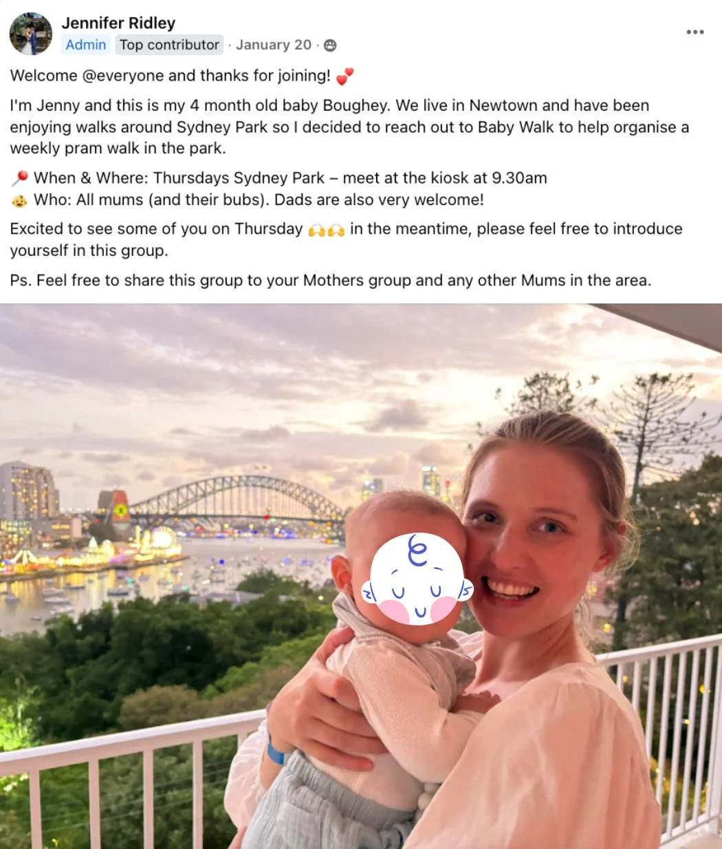 A woman holding a baby with a cityscape and harbor in the background during sunset, with bridge and buildings illuminated.