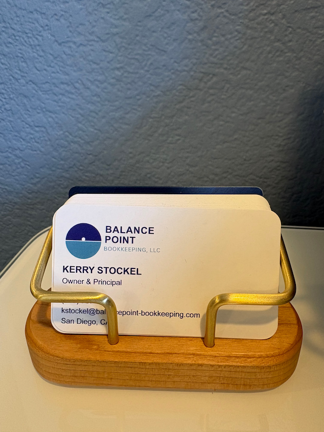 Business cards in a wooden holder for Balance Point Bookkeeping