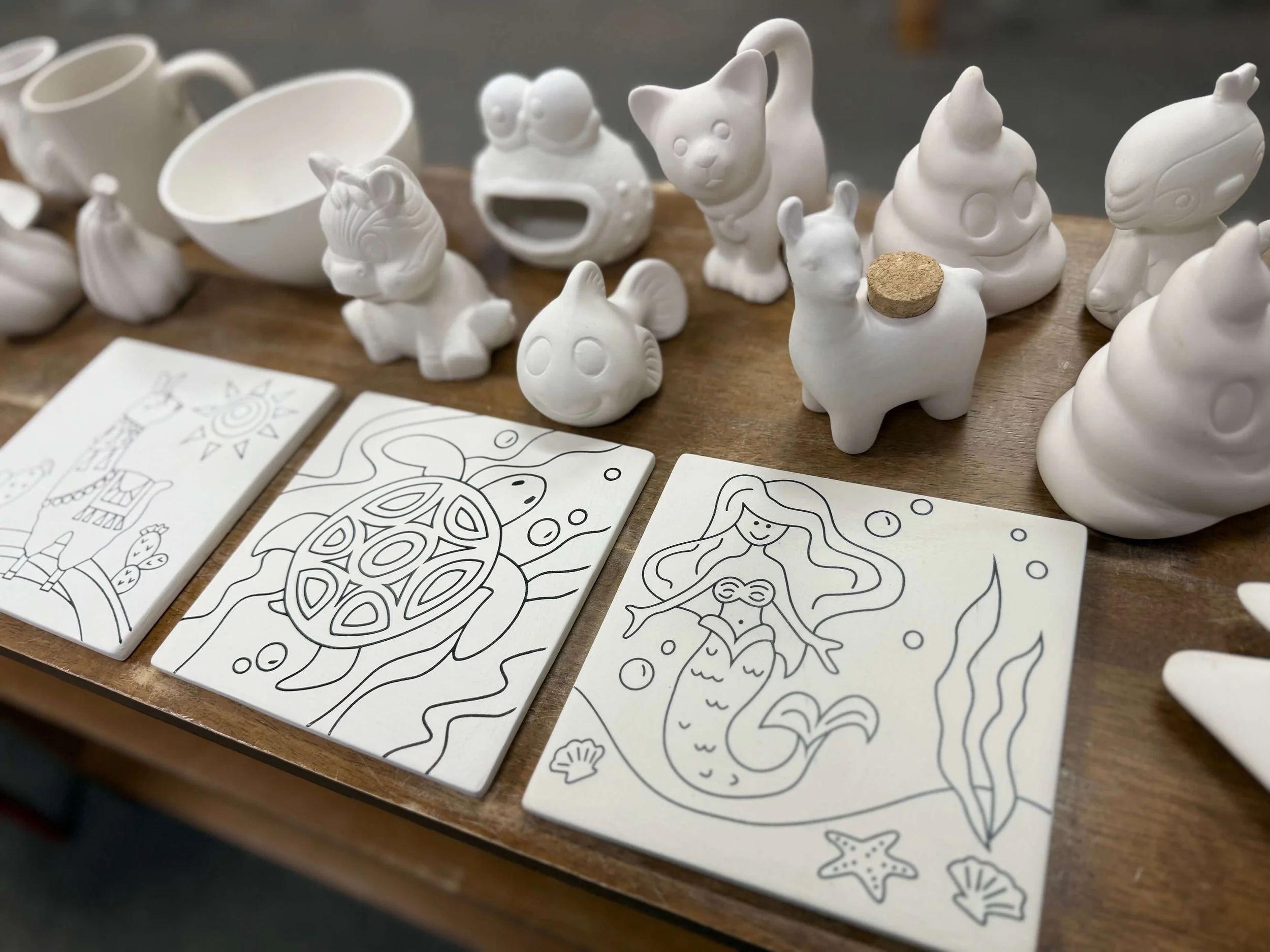 A variety of unpainted pottery statues and tiles