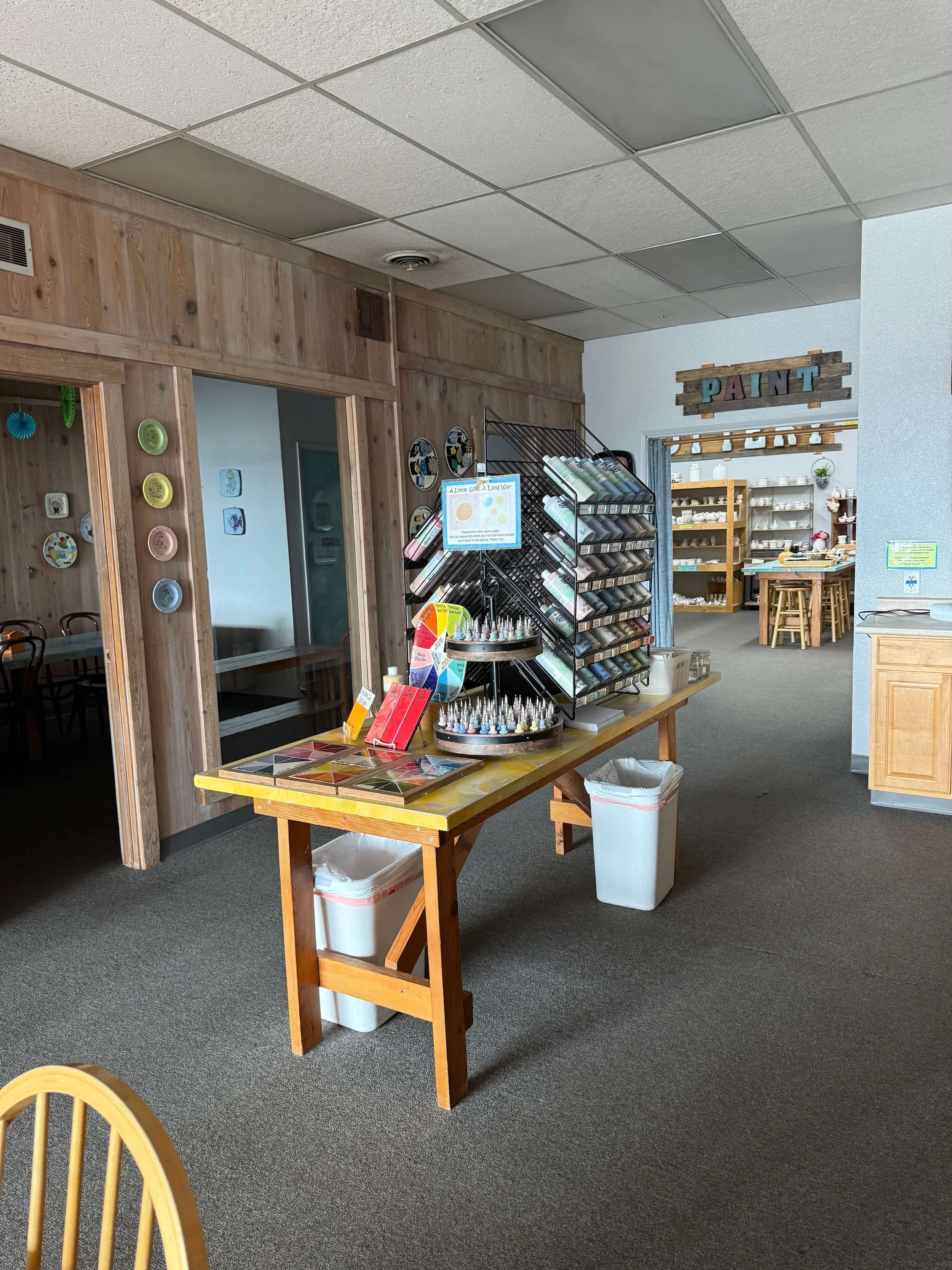 Racks of glaze paint on a table in the studio