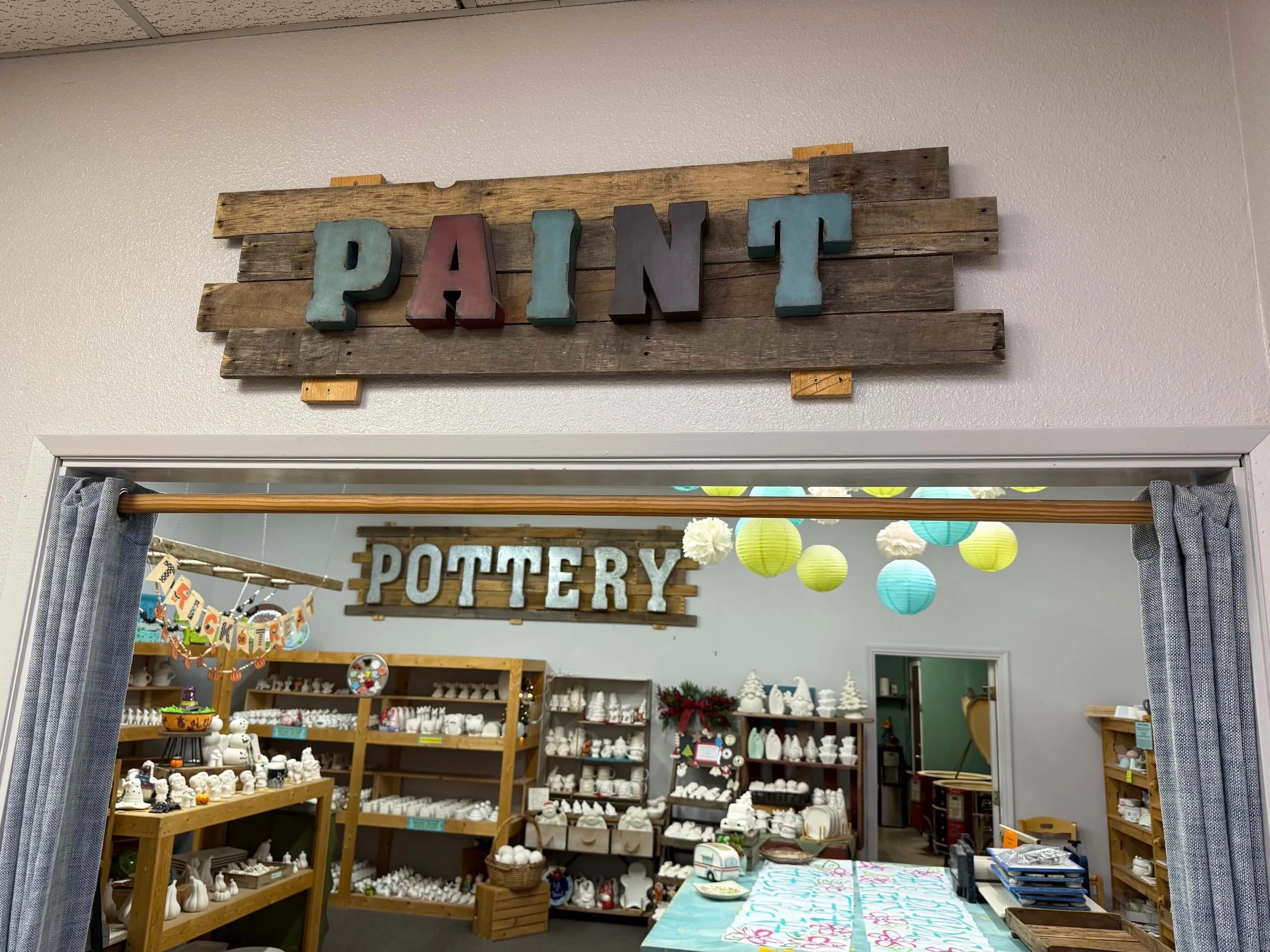 Inside the pottery studio, under a "Paint" sign