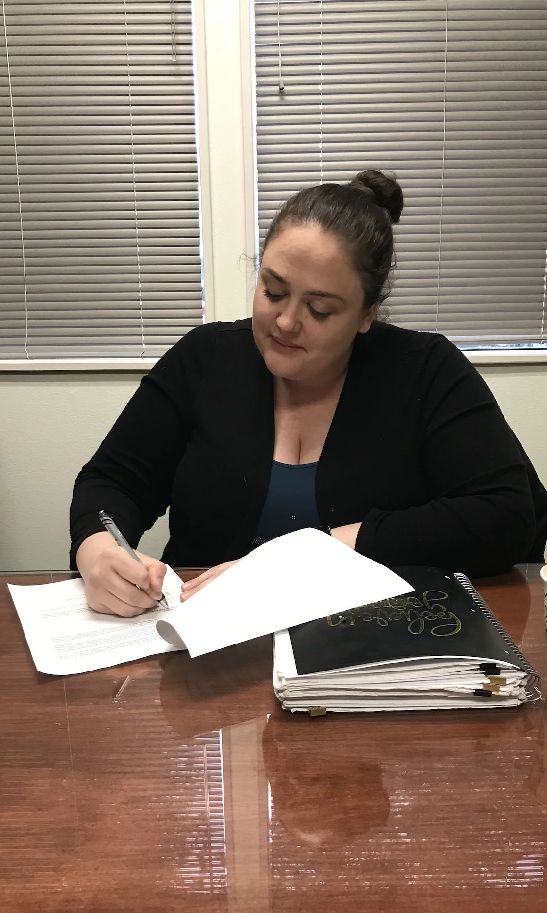 Melissa singing paperwork at a table