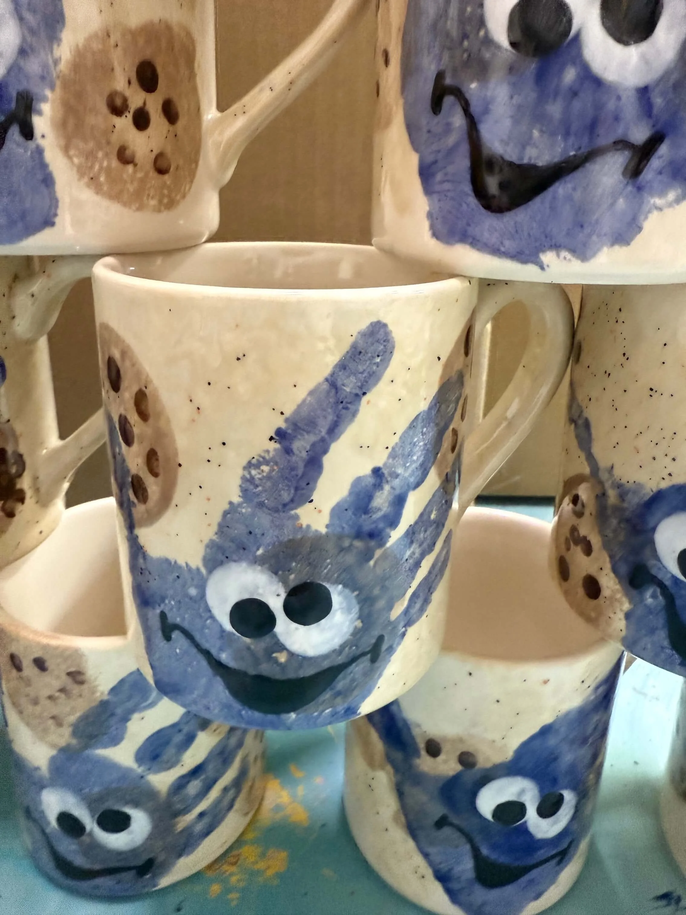 A collection of mugs with painted handprints