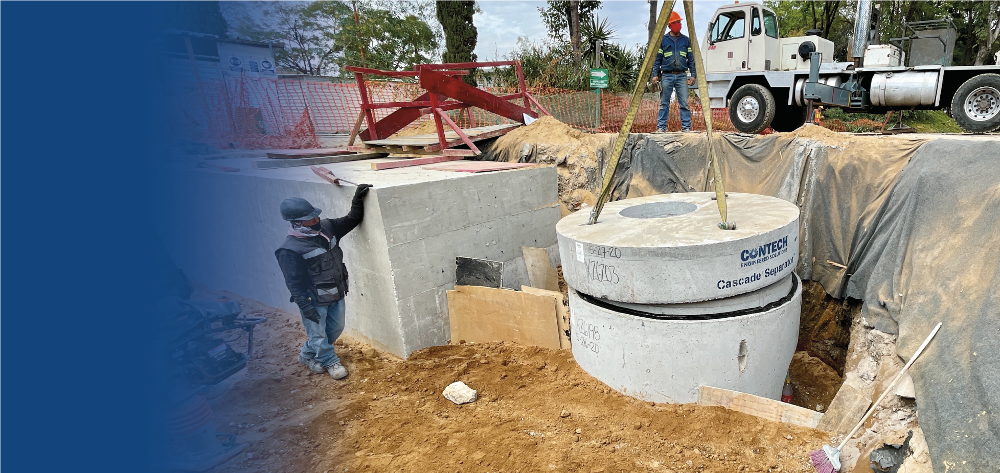 Obra de construcción donde dos trabajadores colocan un separador de cascada de concreto. Uno de ellos lleva puesto un casco y mascarilla, y se encuentra junto a un muro de concreto. En el fondo hay máquinas y equipo de construcción, con tierra y mate