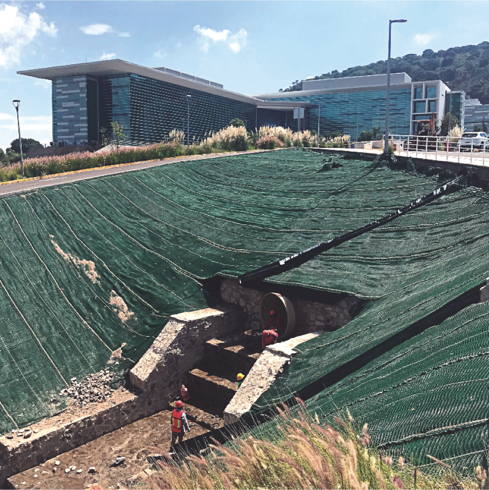 Construcción de un monumento arqueológico con andamios y protección en un área exterior moderna.