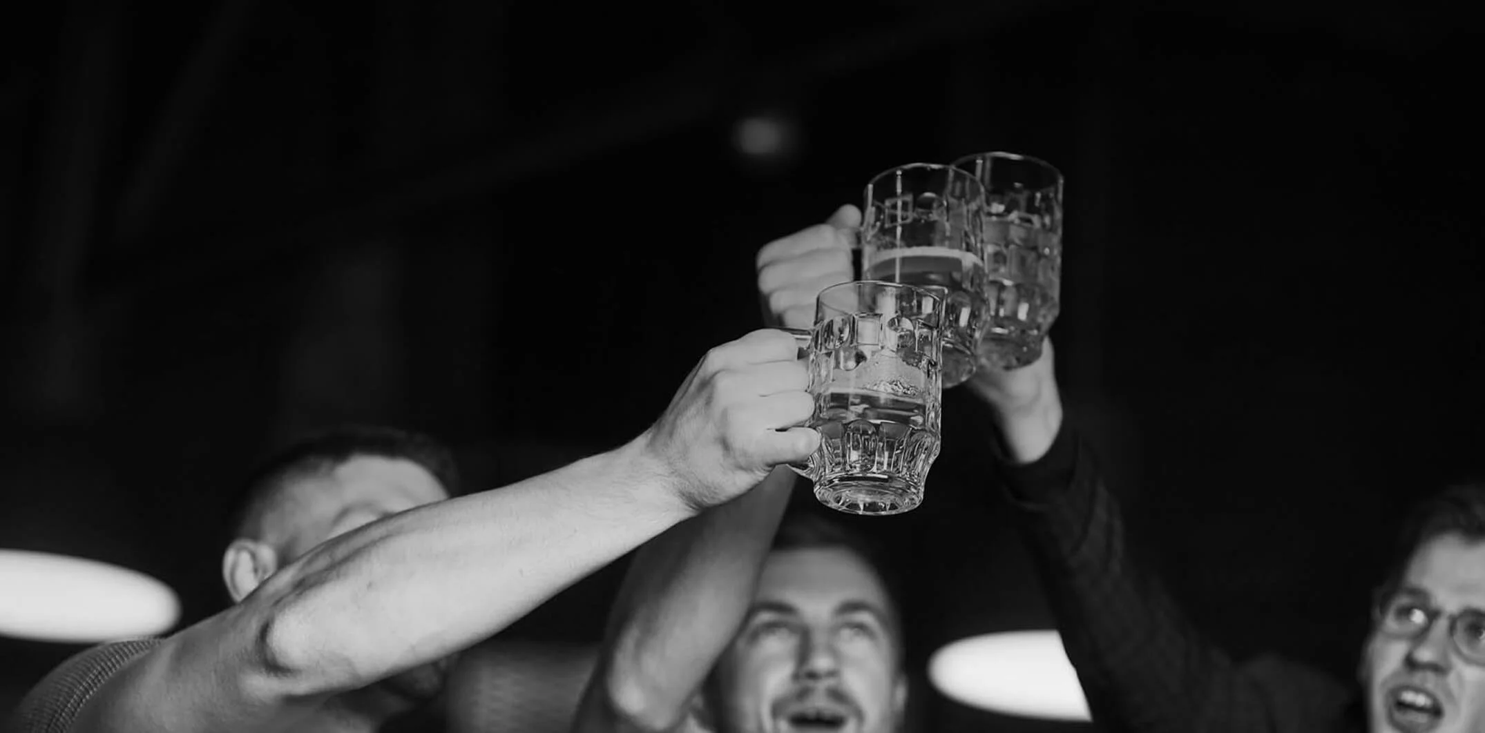 People raising glasses in a toast at a social gathering.