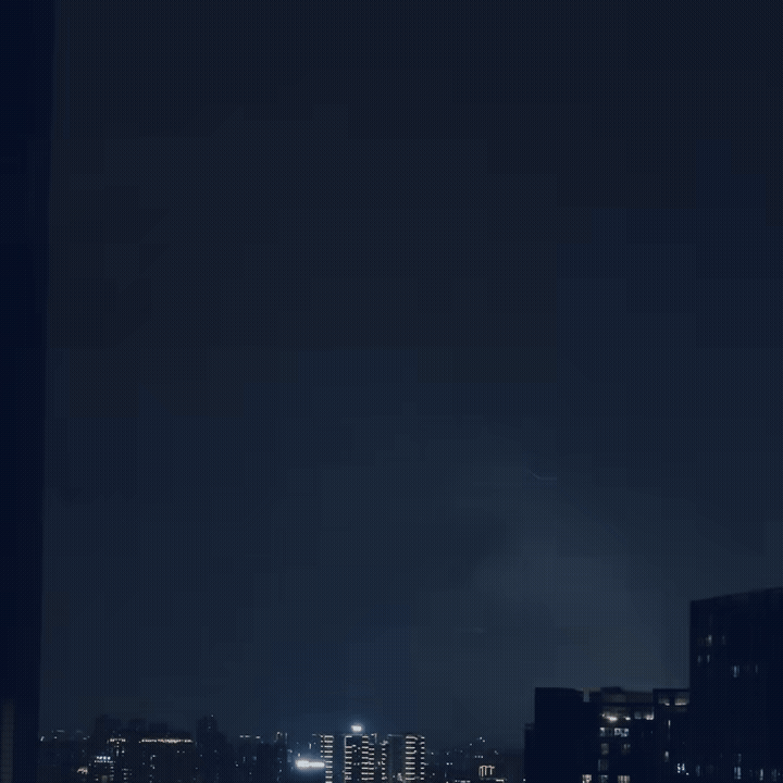Nighttime cityscape with illuminated buildings and a dark sky