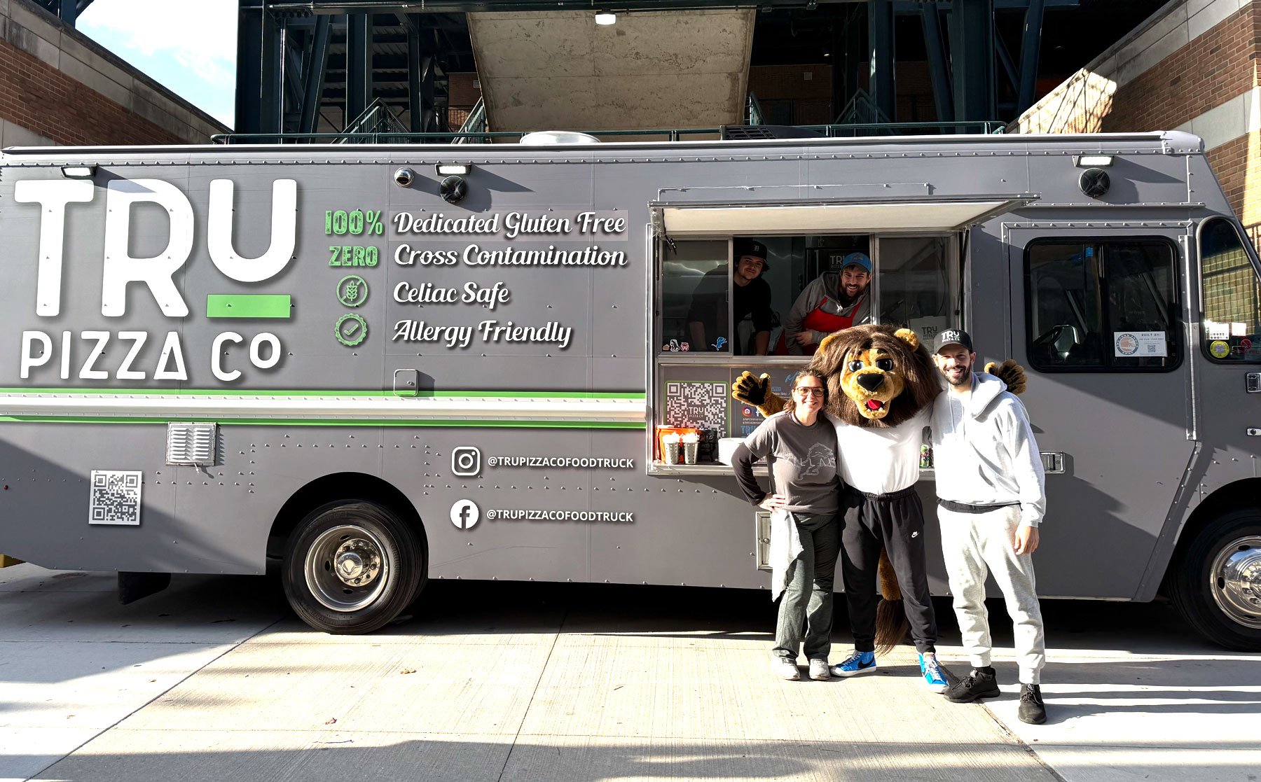 TRU Pizza Co. gluten-free pizza food truck parked at a Detroit Lions game with mascot Roary.