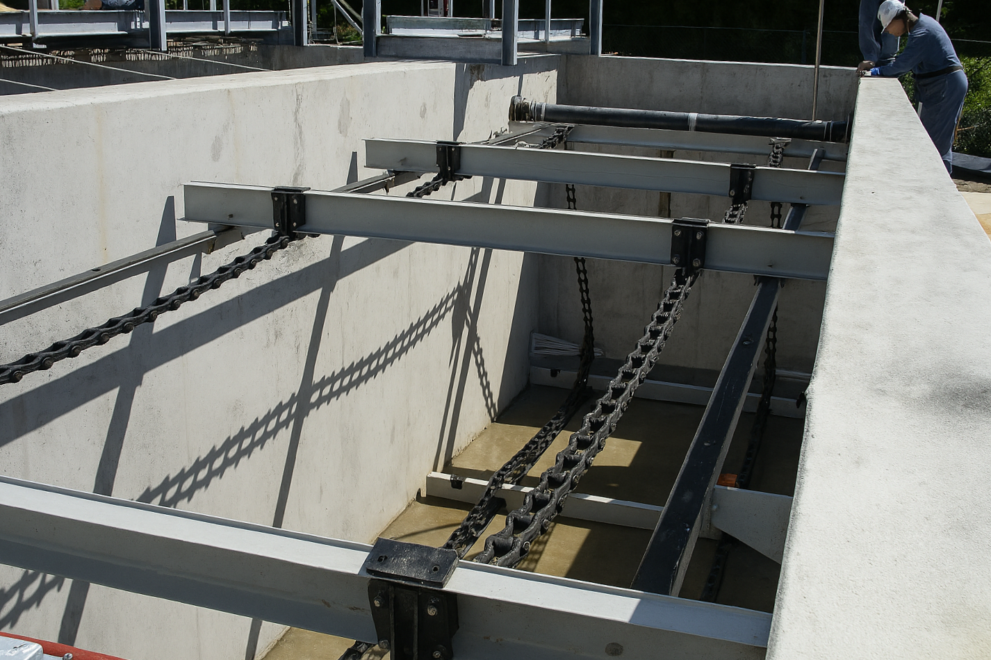 Construction worker standing over a Rectangular Collector used for waste water management