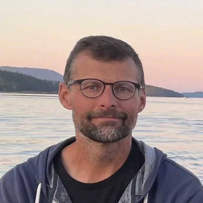 Jon Kusner standing in front of the ocean.