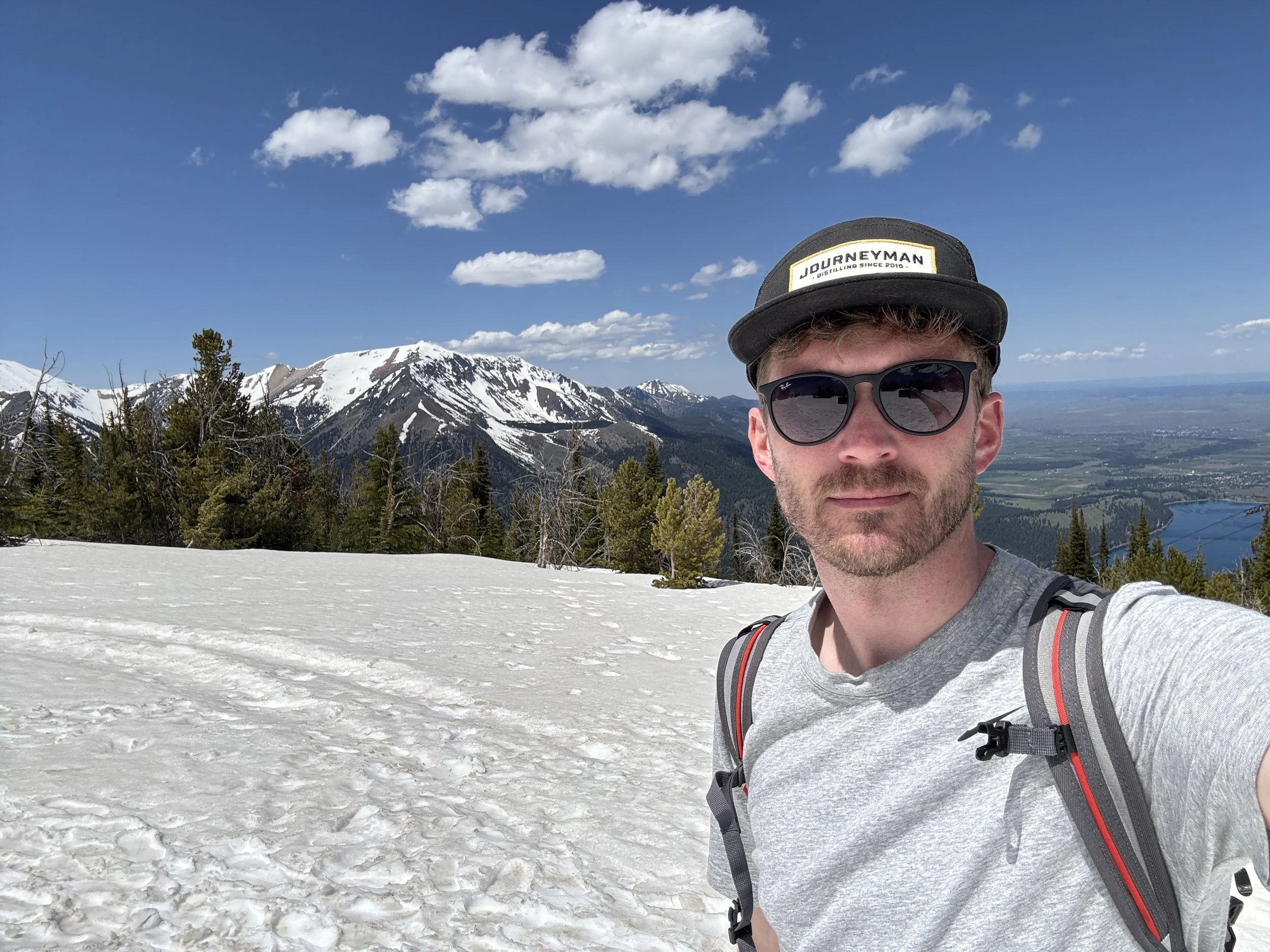Travis Hagenbuch standing at the top of a mountain.
