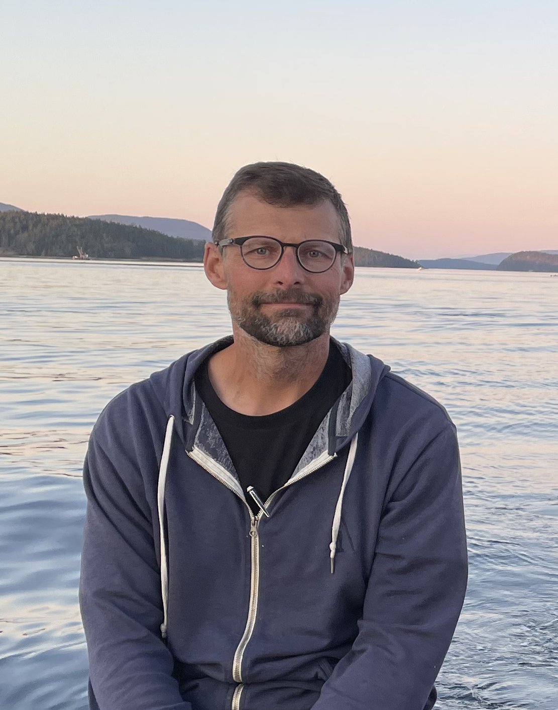 Jon Kusner standing in front of the ocean.
