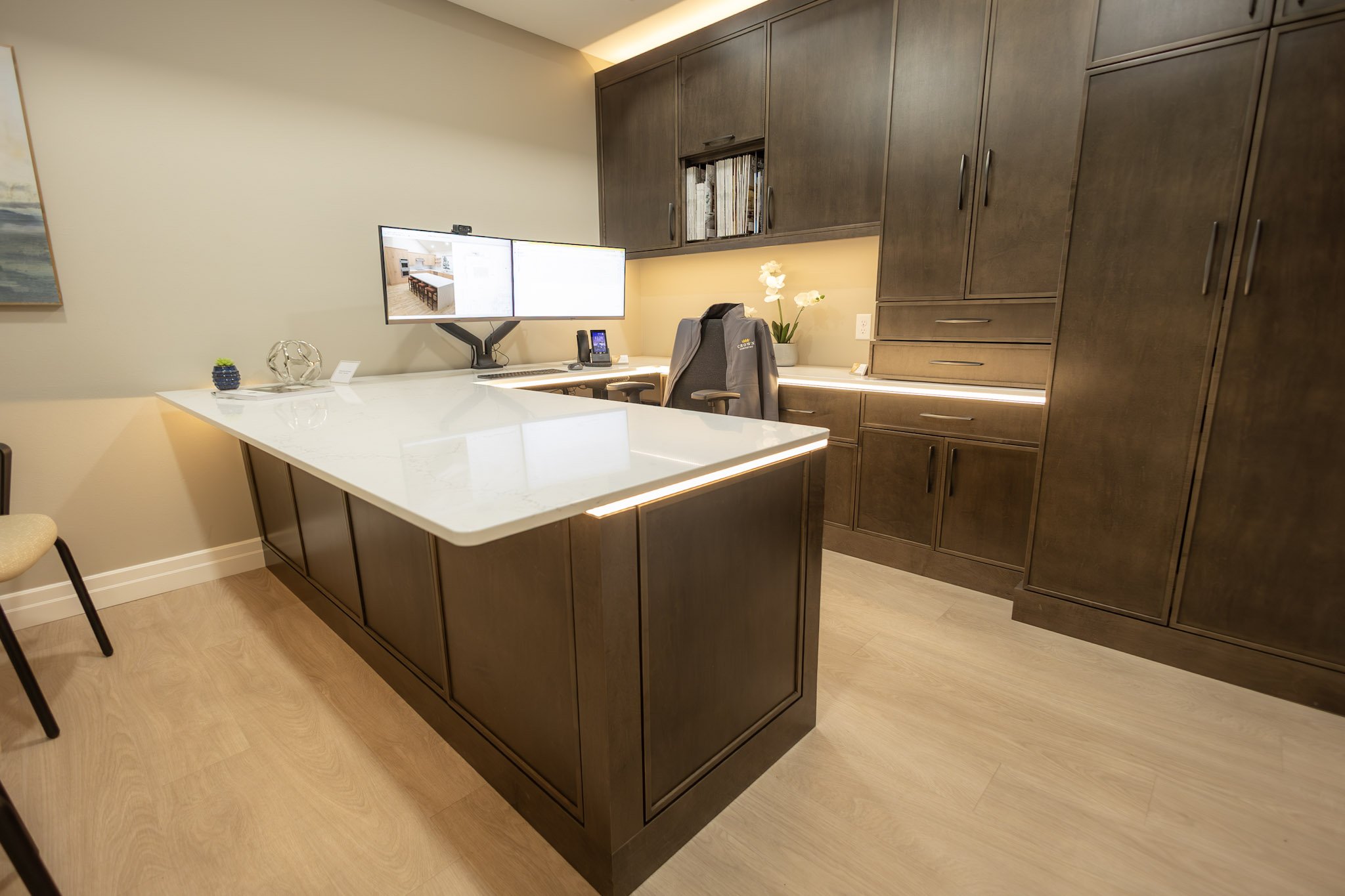 Custom dark wood office cabinetry and a modern wraparound desk designed by Crown Cabinetry in Chetek, Wisconsin.