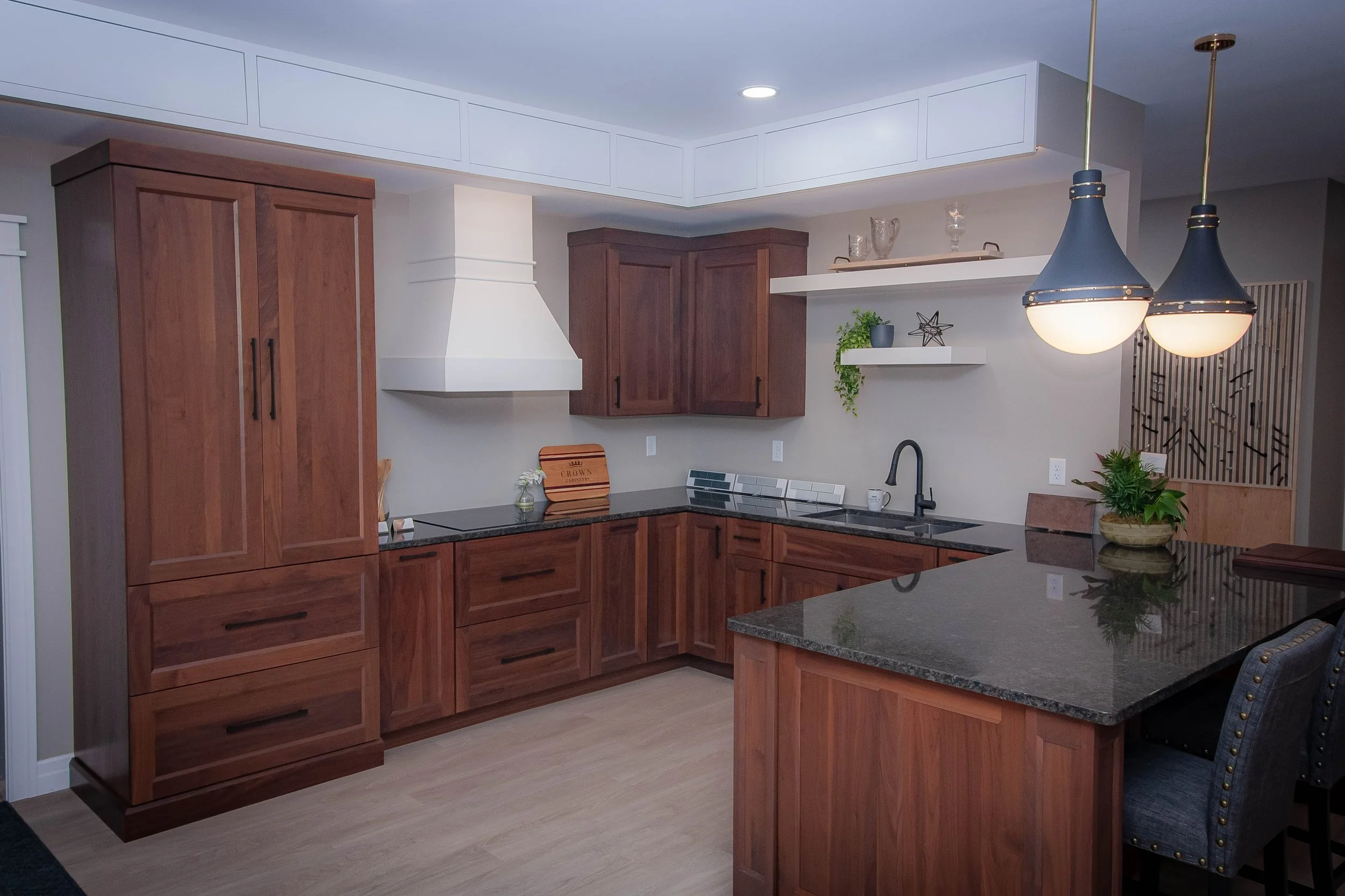 Rich dark wood kitchen cabinetry paired with a high-contrast statement white plaster-style range hood display.