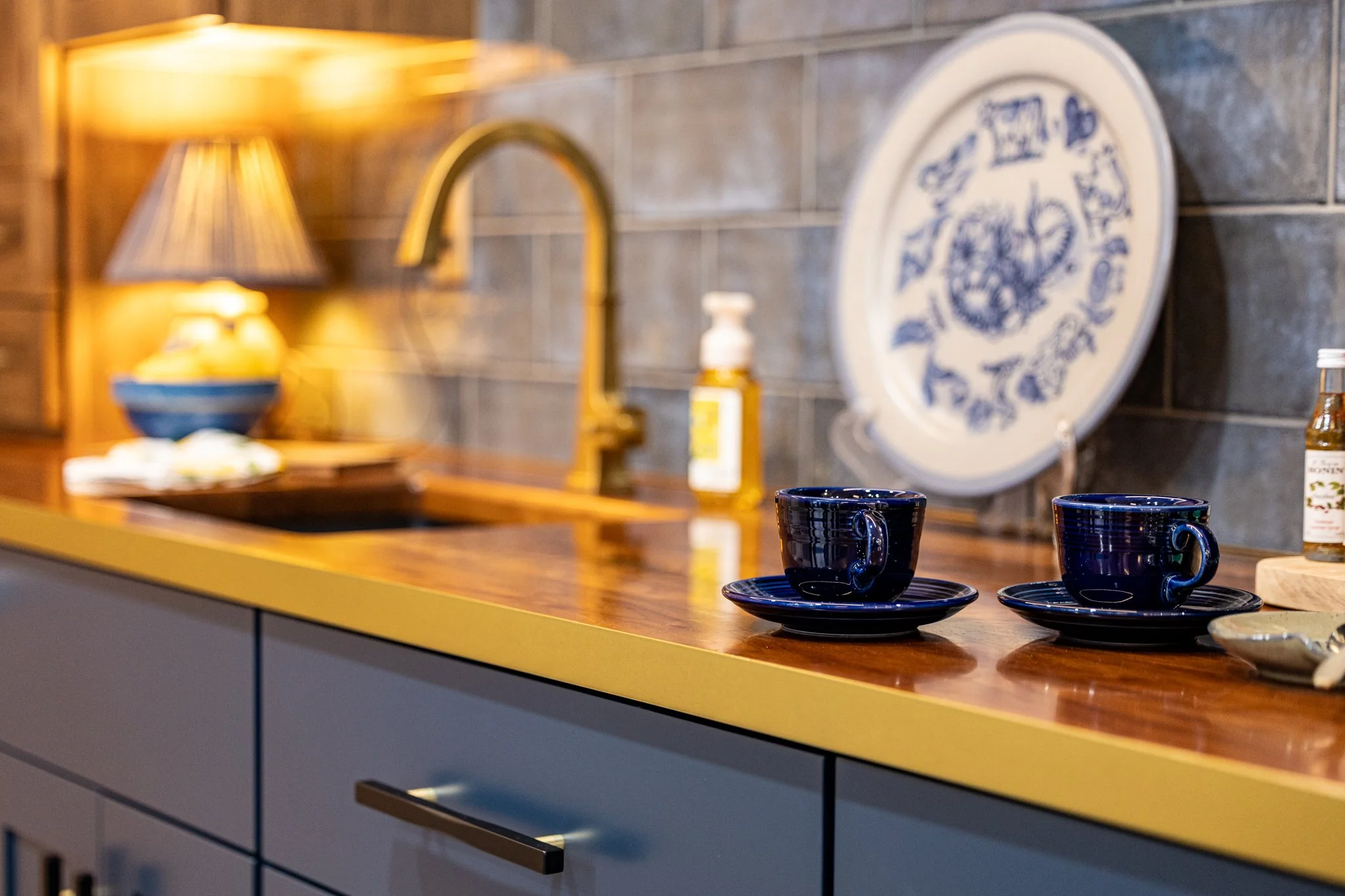 Custom kitchen design by Crown Cabinetry in Chetek, WI, showcasing a warm wood countertop paired with modern blue cabinets and elegant hardware