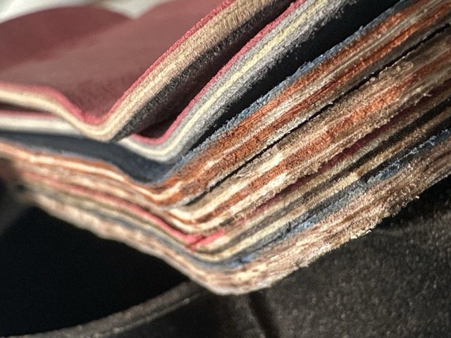 Stacked mini fingerboard skateboards made up of various colours and sizes sitting on a machine.