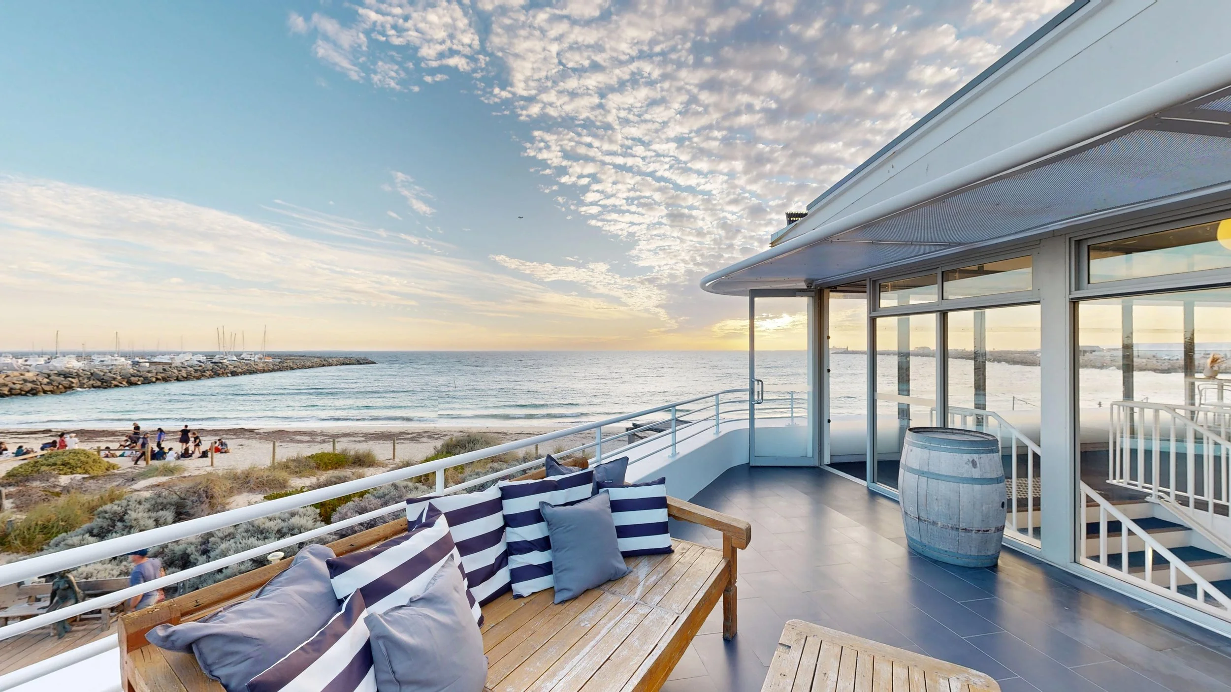 The upstairs balcony at Bathers Beach House, Fremantle, looking over Bathers Beach and the ocean at sunset