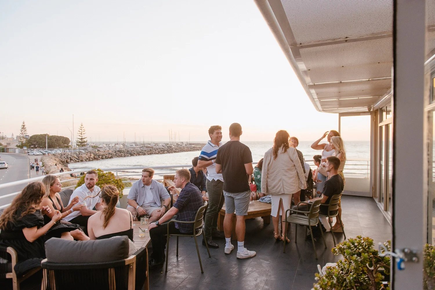 Guests on the balcony at sunset at Bathers Beach House