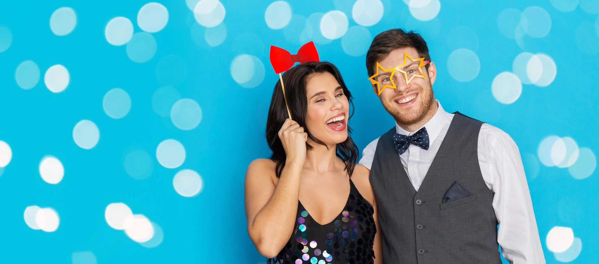 Couple posing with props at photo booth.