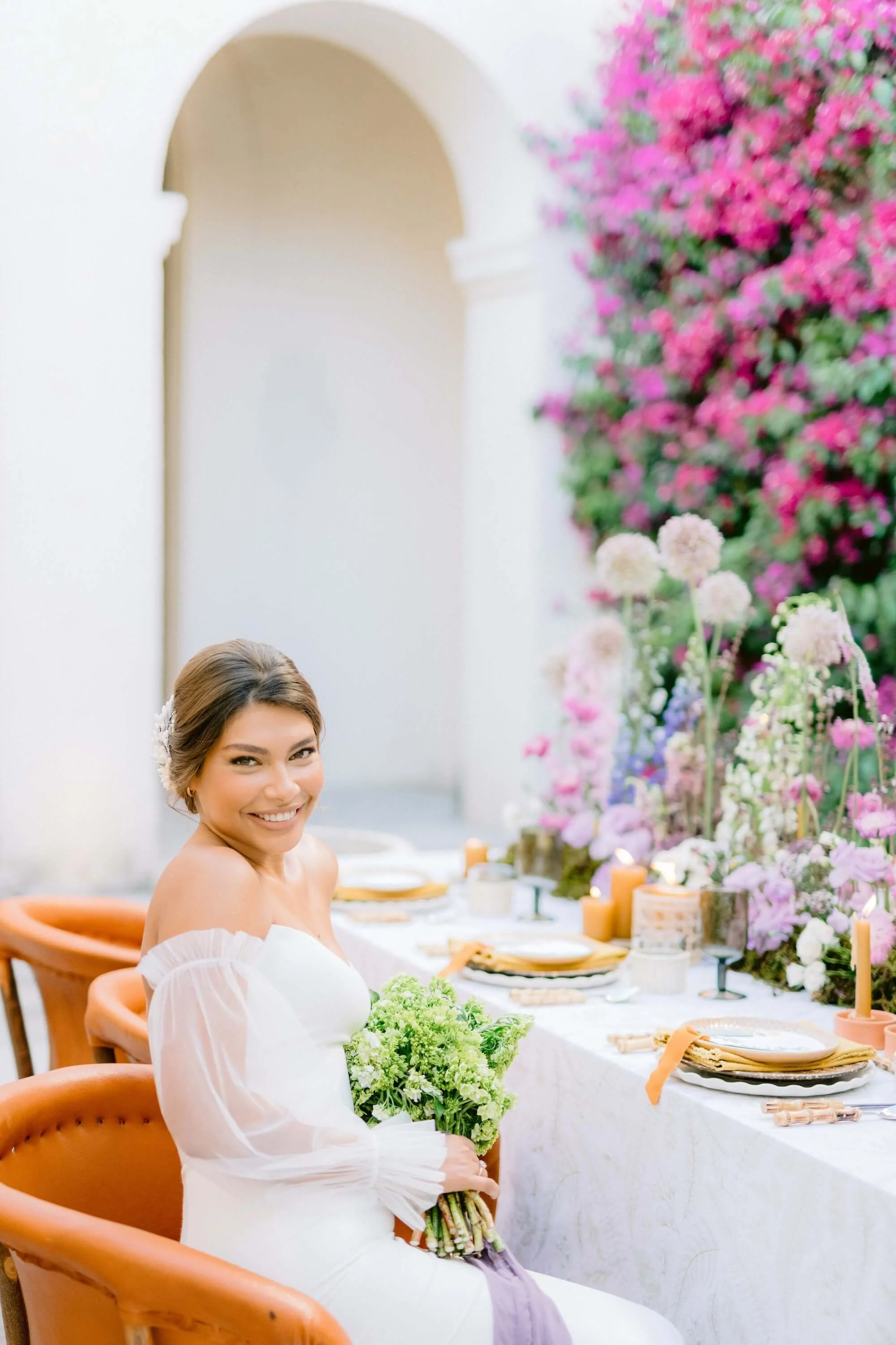 vibrant wedding tablescape with colorful wildflower arrangements and bougainvillea backdrop