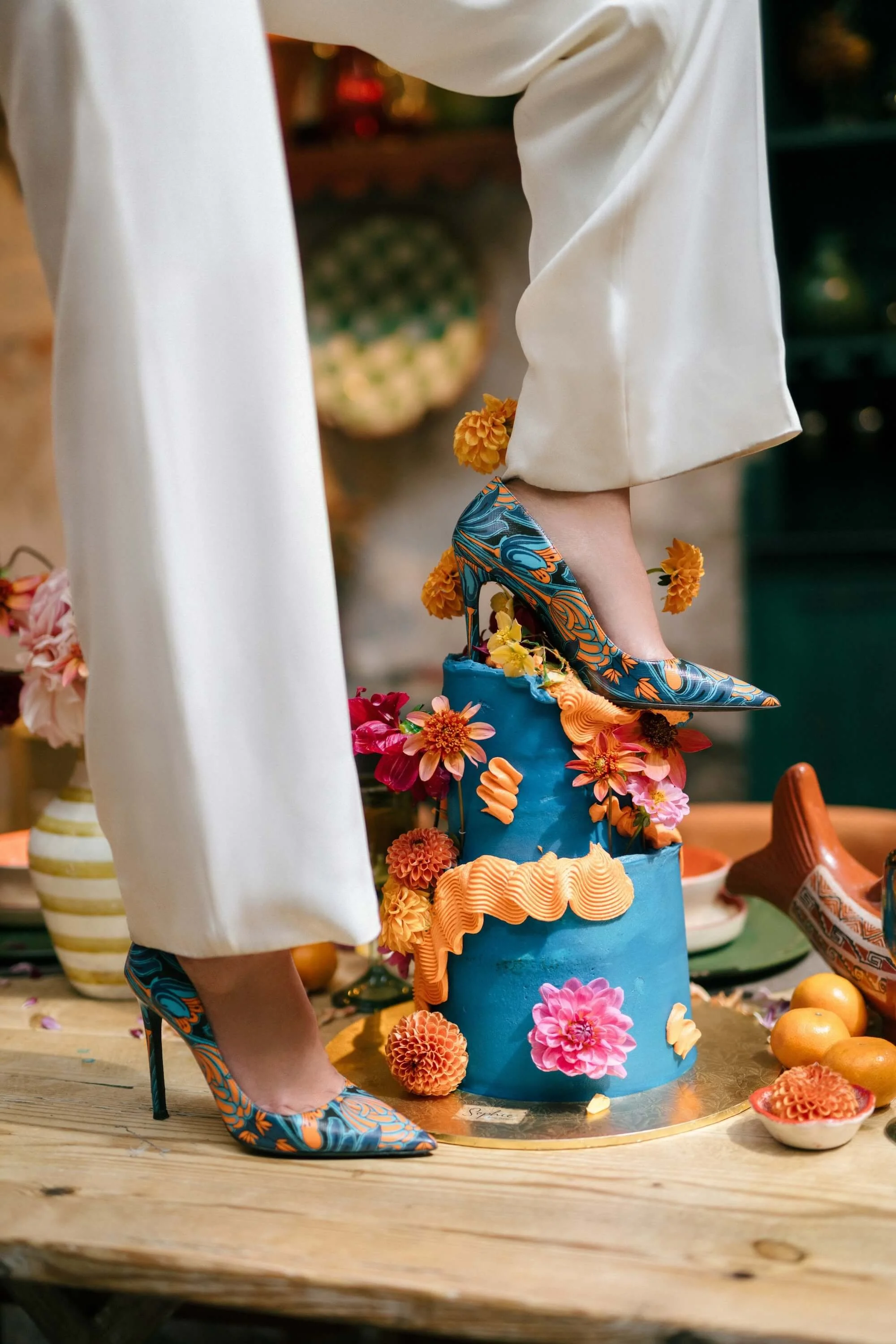 contemporary bride and groom posing near pool with bold floral backdrop