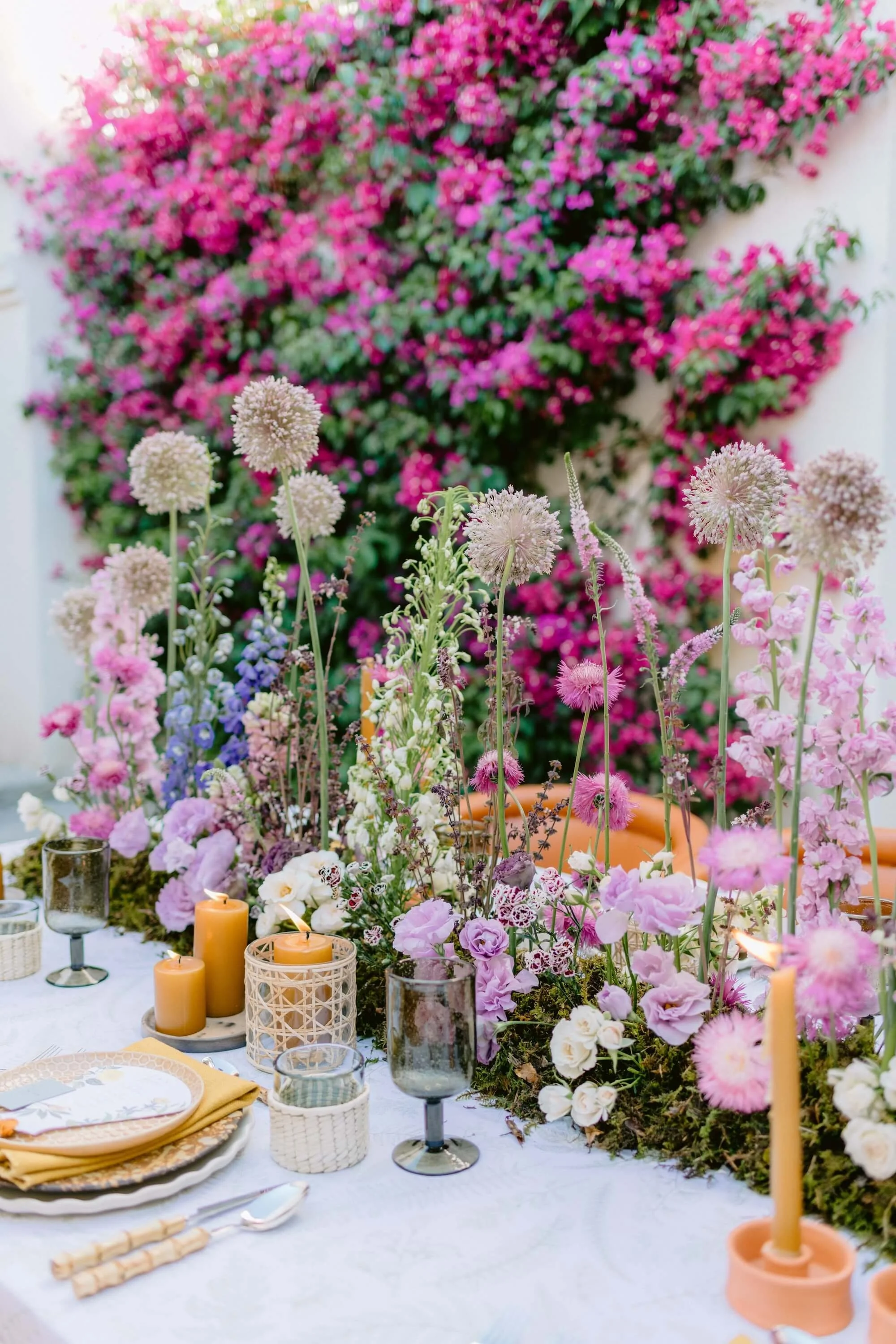 bride raising bouquet surrounded by soft floral installations and candles