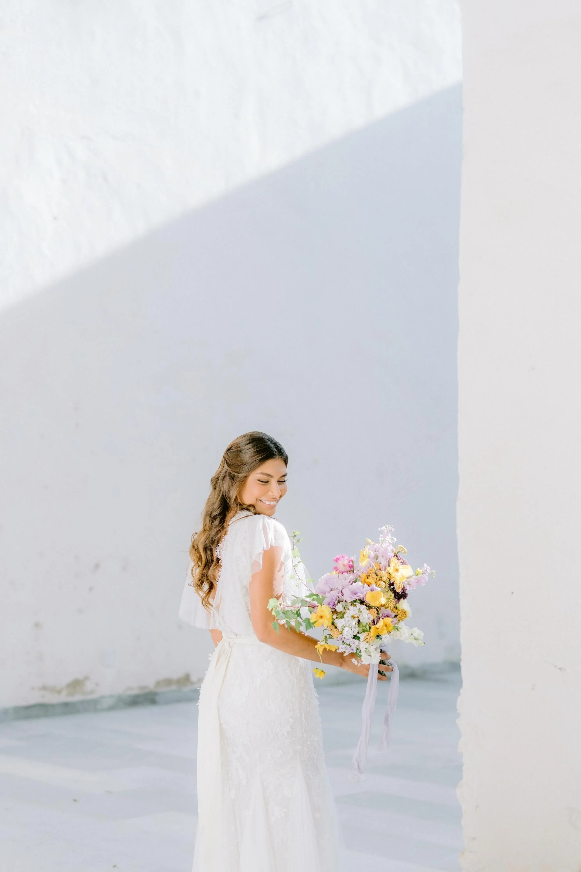 luxury wedding moment with bride holding pastel bouquet and organic floral arrangements