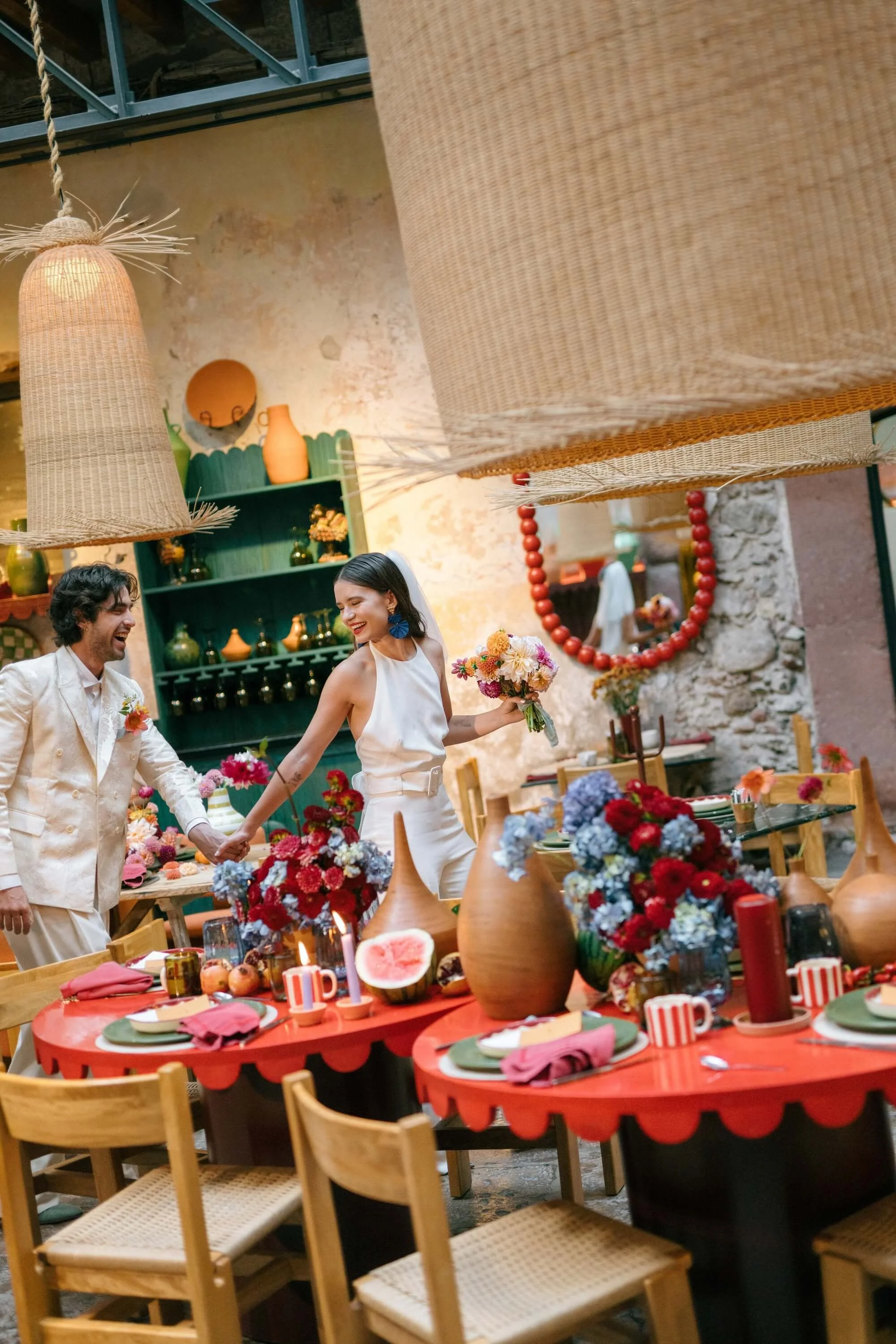 artistic event design with red table, florals and handcrafted decorative elements