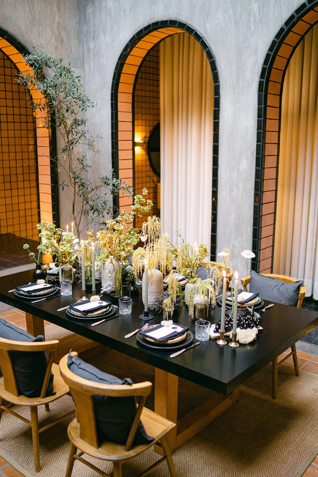 Luxury wedding couple under architectural arches with modern floral bouquet in neutral tones