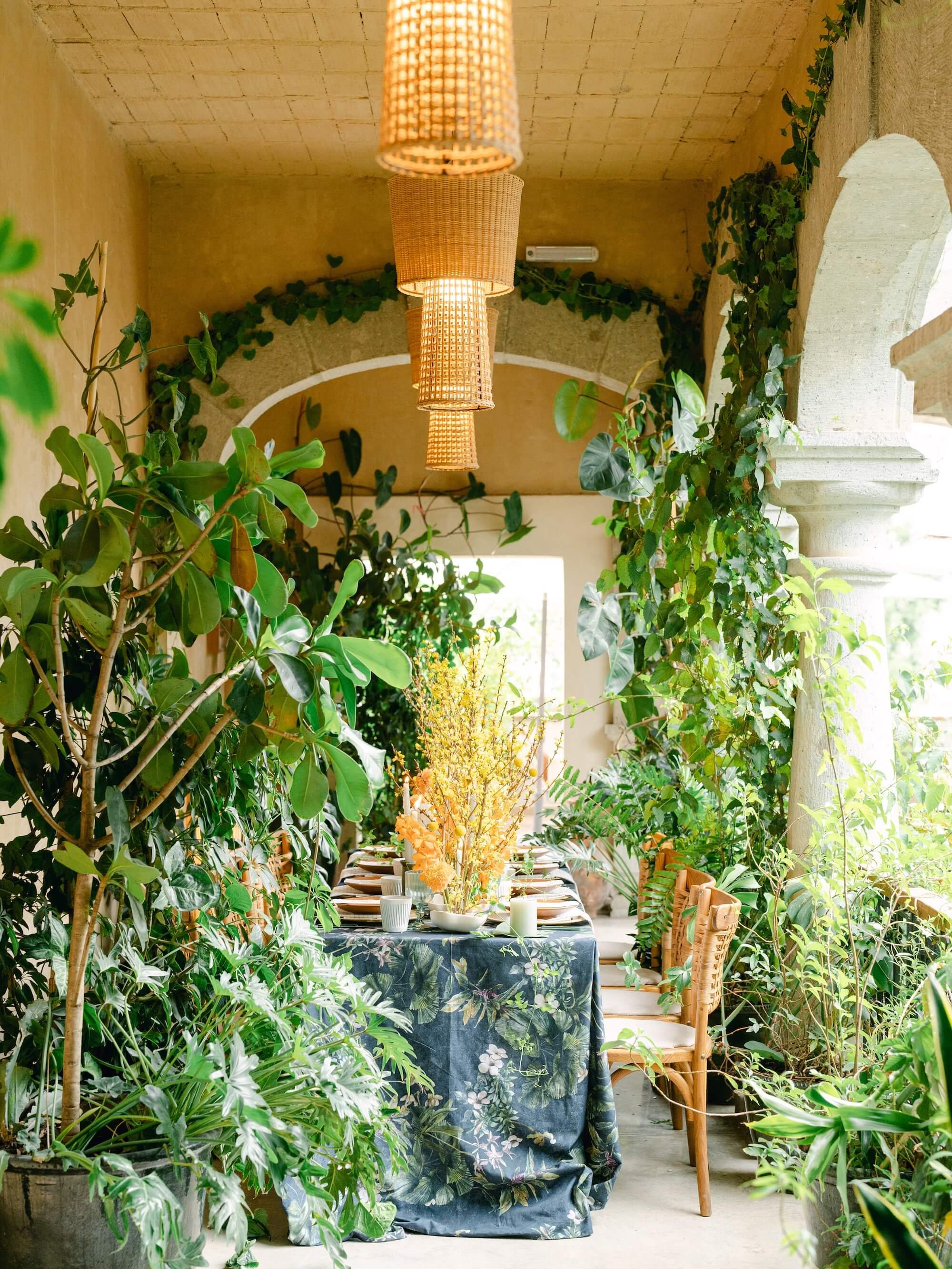 tropical botanical wedding setup with lush plants and yellow floral centerpiece