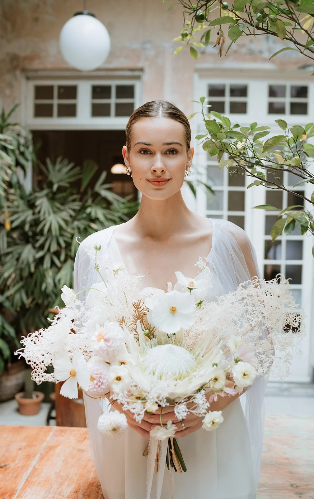 bride sitting in vintage convertible car with modern wedding styling