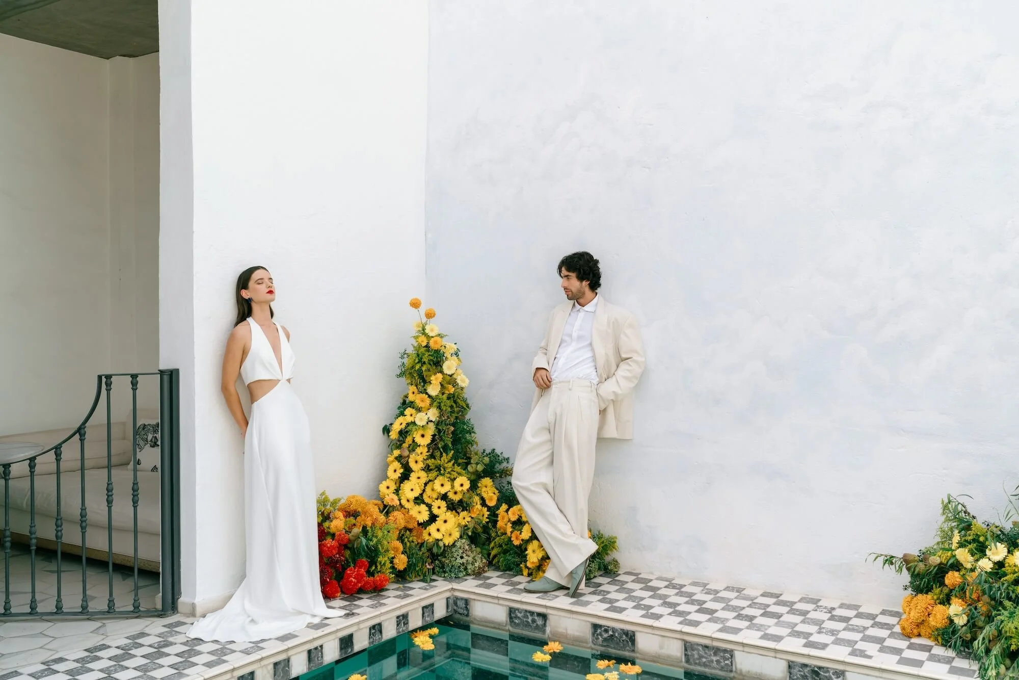 stylish couple portrait with yellow floral arrangement and clean white walls