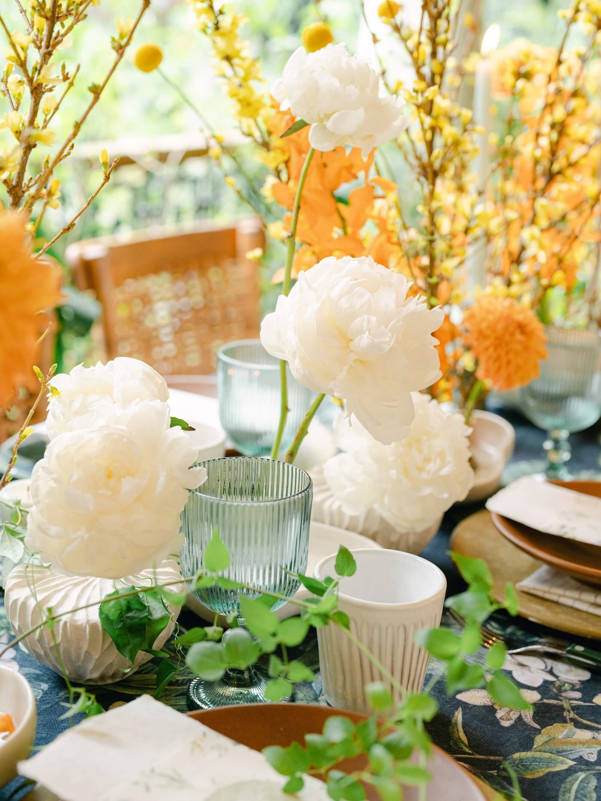 lush green wedding tablescape with tropical plants and hanging lanterns by Florklor