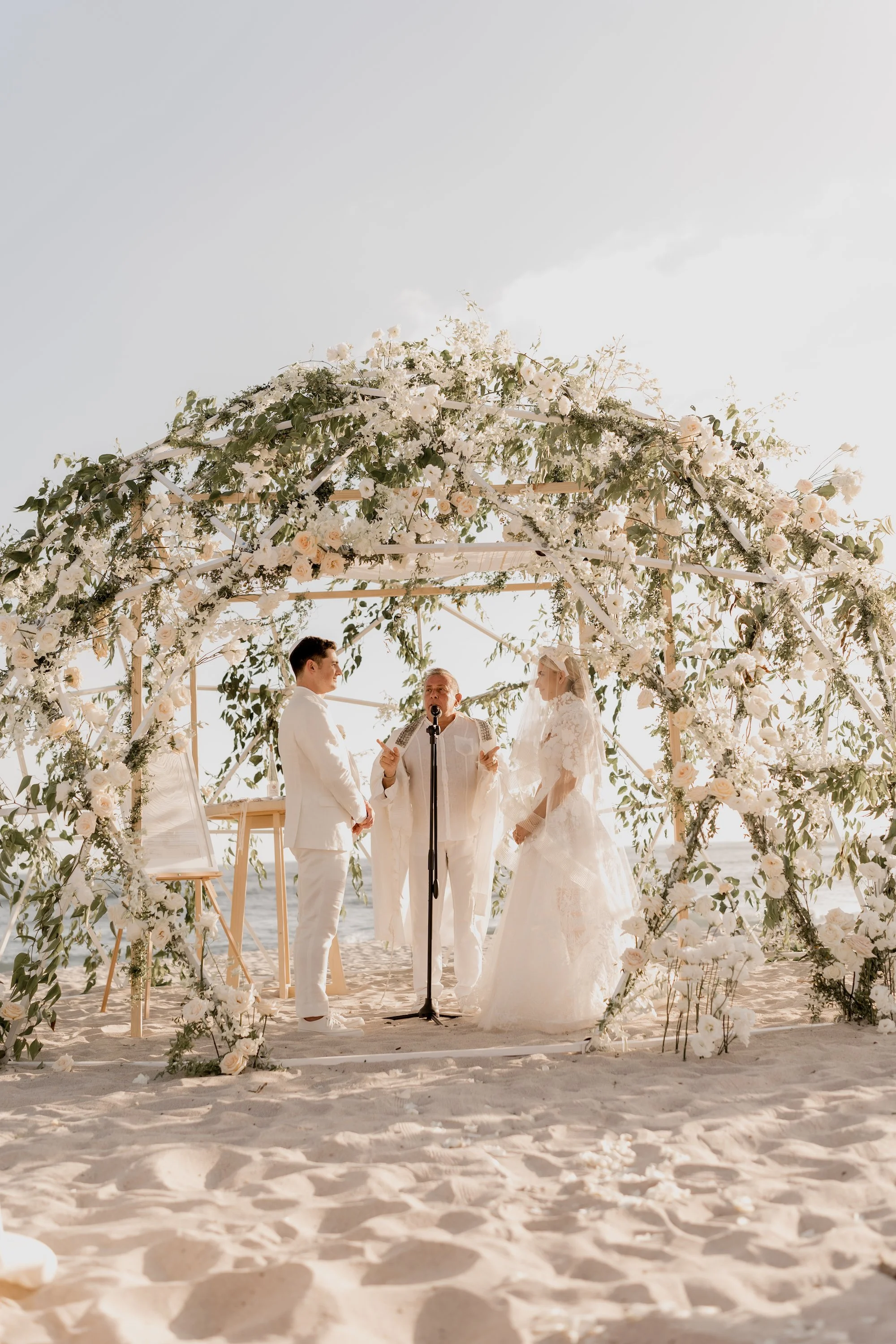 bride and groom surrounded by floral design luxury wedding mexico