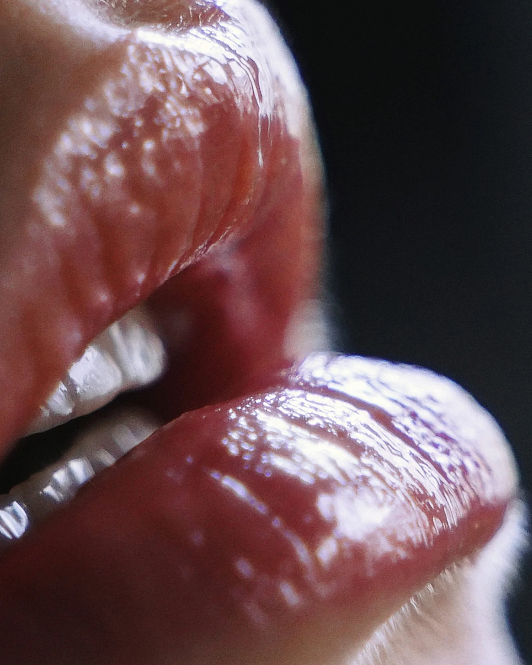 Close-up of a person's lips and teeth, with lips slightly parted and moist.