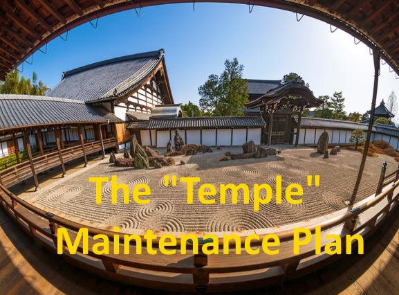 Traditional Japanese Zen garden with rocks and raked sand, surrounded by wooden buildings and trees, viewed through a wooden arch