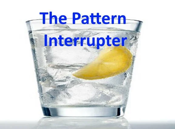 A glass of water with ice and a lemon wedge, with the words 'The Pattern Interrupter' written in blue text.