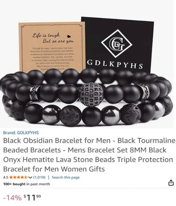 Three black beaded bracelets, including one with a detailed black and silver design, displayed with two cards, one featuring a motivational quote and the other with a brand logo, on a white background.