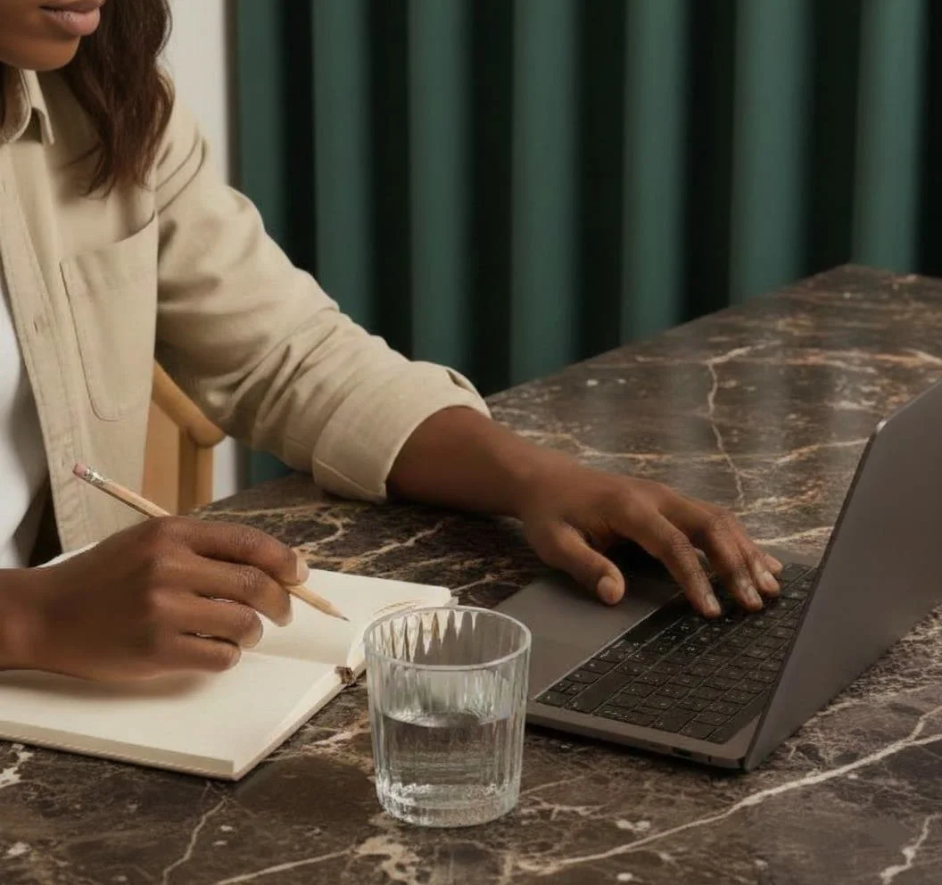lady writing in notebook and searching laptop