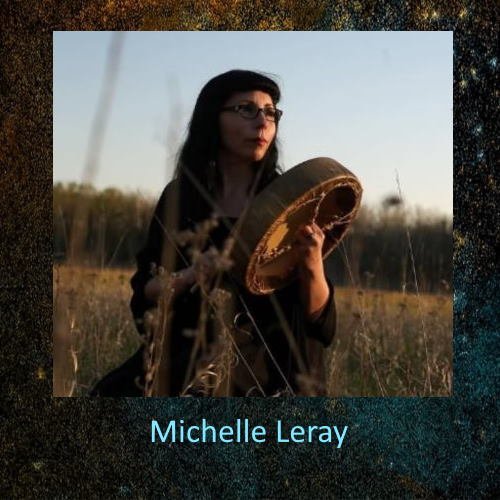 A woman with dark hair and glasses holding a tambourine in a field during sunset.