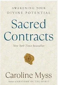 Book cover titled 'Sacred Contracts' by Caroline Myss with the subtitle 'Awakening Your Divine Potential' and a decorative gold seal.