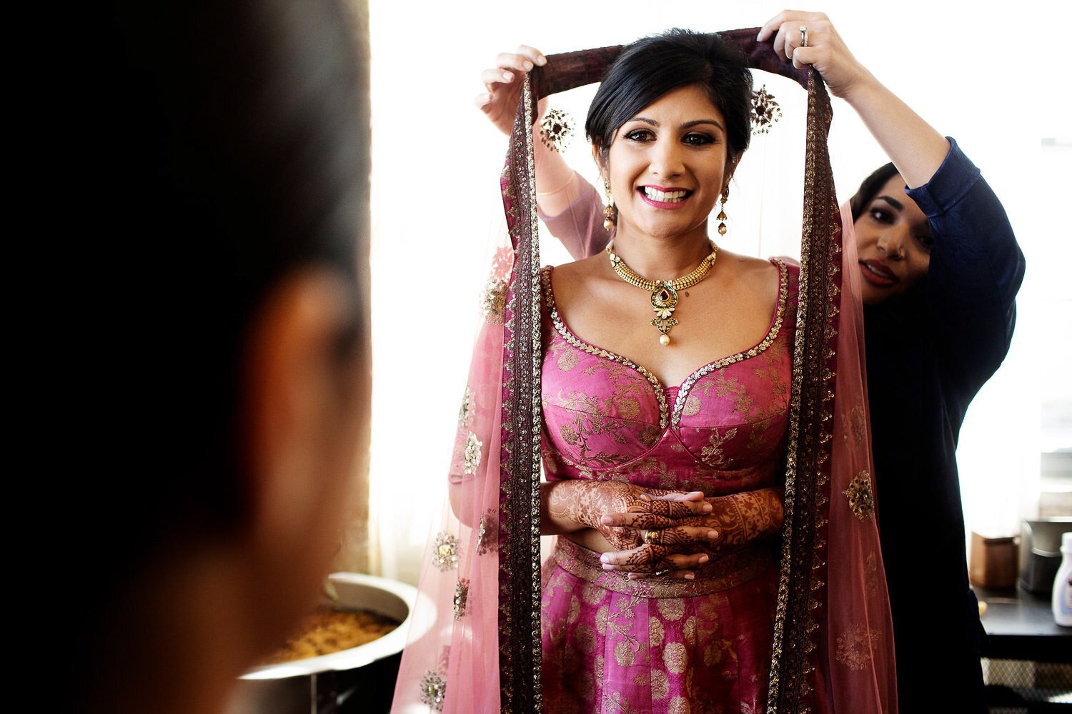 Beautiful Indian bride getting dressed for her wedding - event design by Rocket Science Events, photo by Photogen Inc.