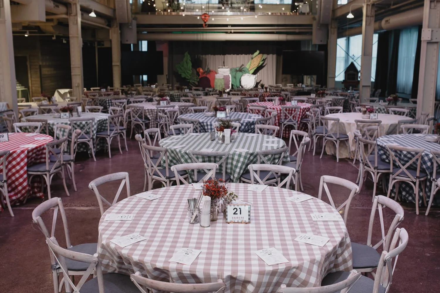 mixed color plaid tablecloths on round tables with white chairs for Americana farm themed event